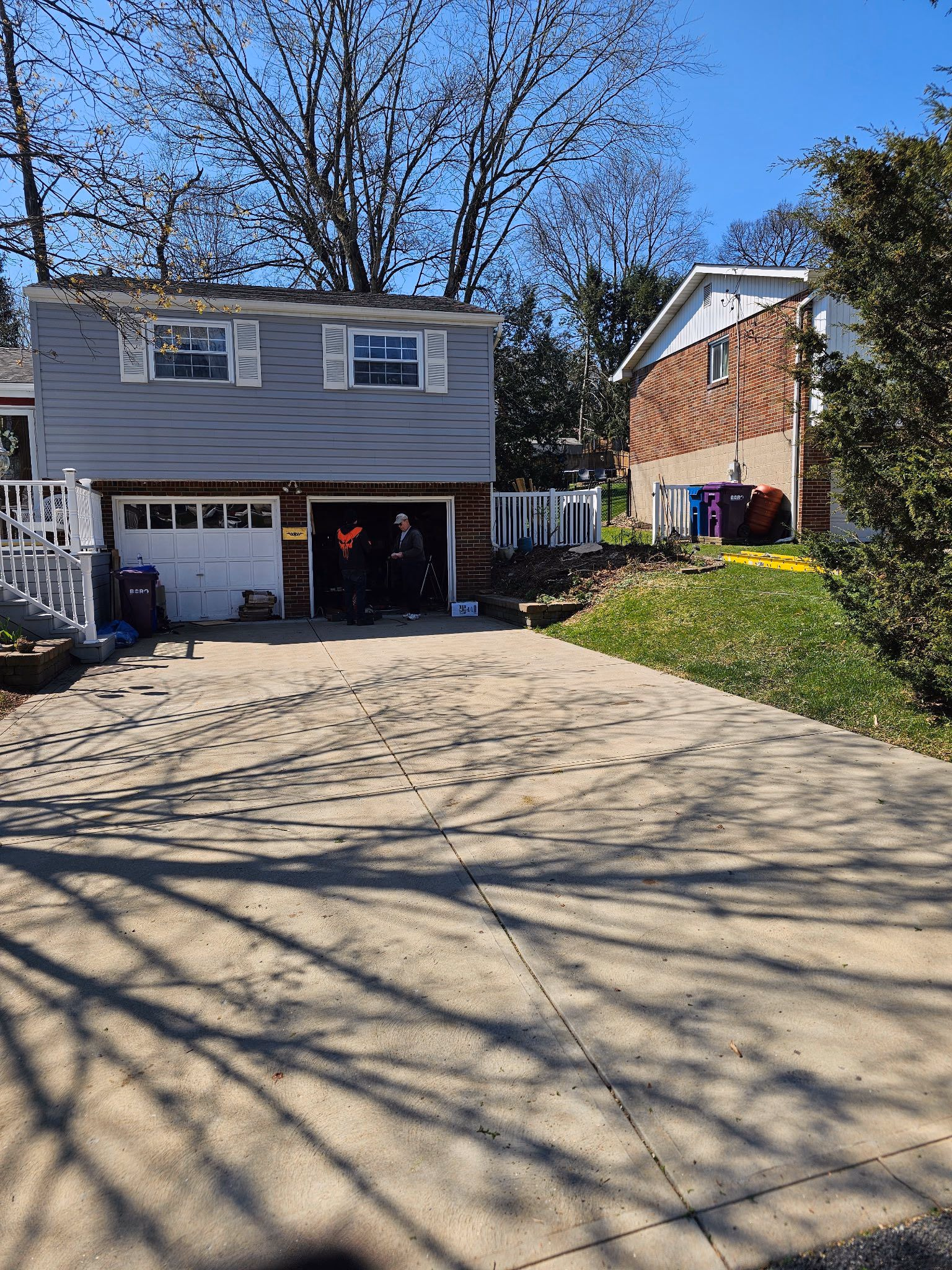 After: the same garage and driveway with the evergreen trees removed.