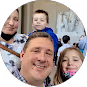 Smiling man, woman, and two children posing closely for a group photo indoors.